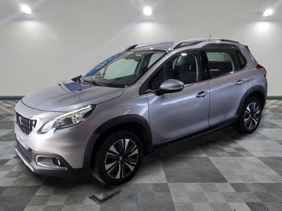 une voiture argentée est garée dans une pièce au sol en damier