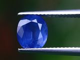 un gros plan d'un saphir bleu tenu par une pince