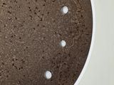 a chocolate cake with white dots on it on a white plate