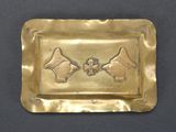 brass plate with two birds and a bird on it on a black surface