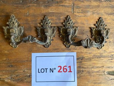 trois poignées de porte en laiton vieilli et une pancarte posée sur une table en bois