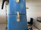 two blue suitcases sitting on a shelf next to each other