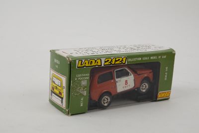 un petit camion-jouet dans une boîte, posé sur une surface blanche, avec un fond blanc