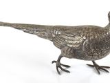 un oiseau en métal posé sur une surface blanche