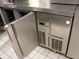 a stainless steel refrigerator in the middle of a kitchen