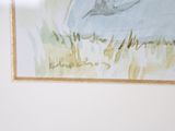 a picture of a painting hanging on the wall above a bed