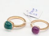 pair of gold rings with green and purple stones and a price tag
