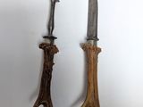 two knives and a fork on a white surface