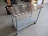 une table en acier inoxydable sur roulettes dans une pièce