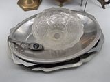 a silver plate with a glass bowl on top of it