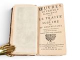 an open book with a gold glove on top of it