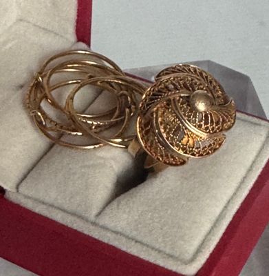 une bague en or dans un coffret rouge posé sur une surface blanche
