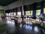 many tables and chairs in a room with large windows