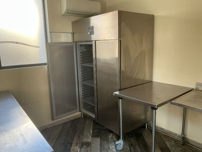 a stainless steel refrigerator and a table in a kitchen
