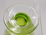 a glass vase with a green liquid inside of it