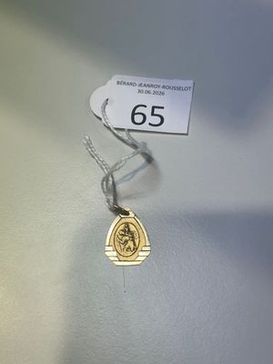 un collier orné d'une pièce d'or, posé sur une table
