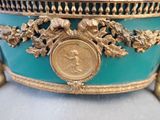 a gold and blue bowl with a coin on it