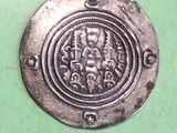 a silver coin with an image of a man and a woman on it