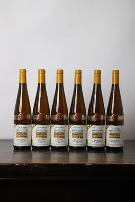 six bouteilles de vin sont alignées sur une table en bois