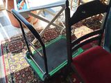 chairs and a table in a room with a potted plant in the background