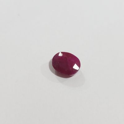 a red ruby stone on a white surface