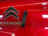 a close up of a citroen logo on a red car