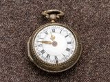 une montre de poche en or avec des chiffres romains