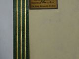 an old book with a green cover and a gold border