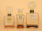 three bottles of perfume sitting next to each other on a table
