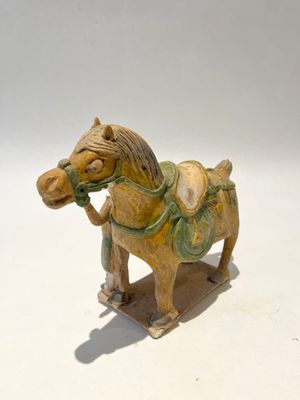 CAVALIER en terre cuite tenant son cheval par la bride, glaç…