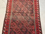 a red and black rug sitting on top of a white floor