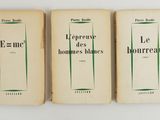 three books sitting on top of a white table next to each other