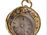 a gold clock with flowers on it on a white background