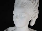 a white statue of a woman with a flower in her hair