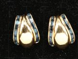 paire de boucles d'oreilles dorées ornées de pierres bleues sur fond noir