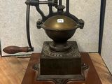 a small antique coffee grinder on a wooden table