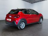 the red car is parked in a large room with a white wall