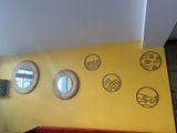 three round mirrors on the yellow wall above a red couch