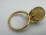 a close up of a gold ring with a large faceted glass ball