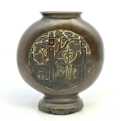 un vase en bronze orné d'un motif sur fond blanc