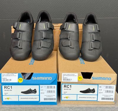 Trois paires de chaussures Shimano sont exposées dans une boîte