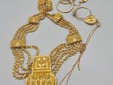 a close up of a gold necklace on a white surface