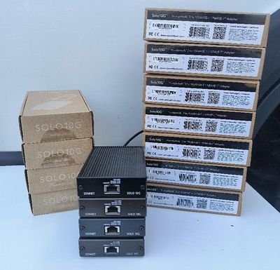 une pile de quatre cartons contenant du matériel électronique