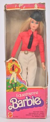 poupée Barbie dans une boîte, vêtue d'un t-shirt rose et d'un pantalon blanc
