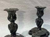 two black candles that are sitting on a white table