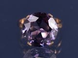 une bague en améthyste ornée d'une pierre violette en son centre
