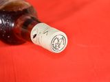 a bottle of wine sitting on a red table cloth