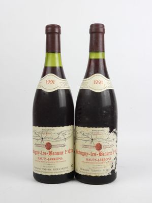 deux bouteilles de vin posées l'une à côté de l'autre sur une surface blanche