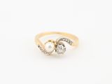 un gros plan d'une bague en or sertie de deux diamants et d'une perle