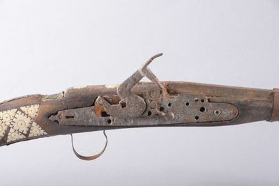 un gros plan d'un fusil avec une crosse en bois
